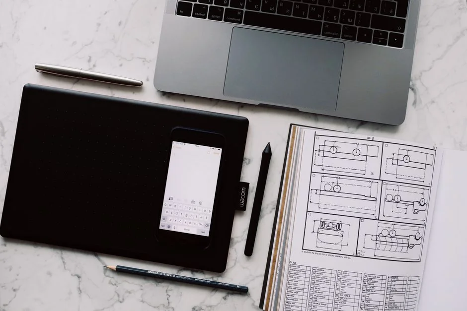 Podrobné grafy a diagramy v dokumentu vedle notebooku, které znázorňují analýzu dat.